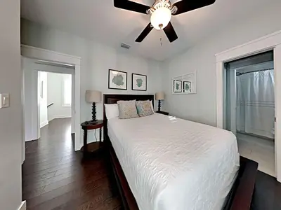 a bedroom with a bed with a ceiling fan at Casa Migos in Rosemary Beach