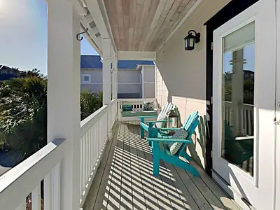 a porch with two chairs and a table at Casa Migos in Rosemary Beach