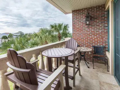 a balcony with two chairs and a table and a grill at Village Of South Walton #263A in Rosemary Beach