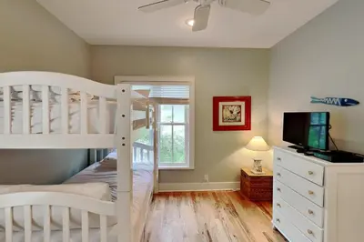 a bedroom with a bunk bed and a tv at Sand Piper in Seacrest