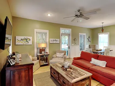 a living room with a red couch and a table at Sand Piper in Seacrest