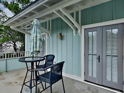 a patio with two chairs and a table on a porch at Sand Piper in Seacrest
