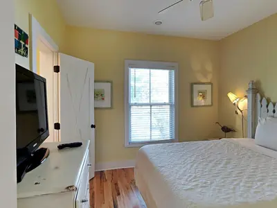 a bedroom with a bed and a tv and a window at Sand Piper in Seacrest