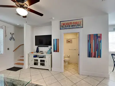 a living room with a toilet and a sign on the wall at Bungalows at Seagrove #147 in Seagrove Beach