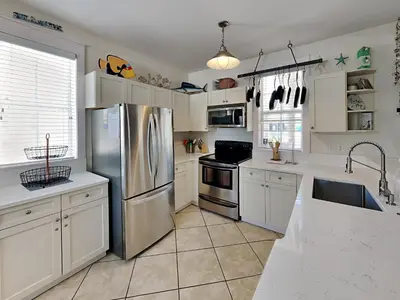 a kitchen with white cabinets and a stainless steel refrigerator at Bungalows at Seagrove #147 in Seagrove Beach