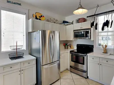a kitchen with a stainless steel refrigerator and white cabinets at Bungalows at Seagrove #147 in Seagrove Beach
