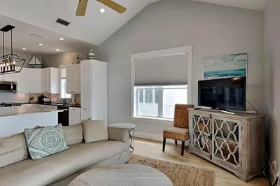 a living room with a couch and a flat screen tv at Magnolia House in Seagrove Beach