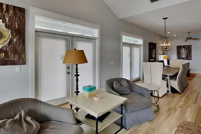 a living room with two couches and a table at Magnolia House in Seagrove Beach