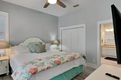 a bedroom with a bed and a desk with a ceiling fan at Magnolia House in Seagrove Beach