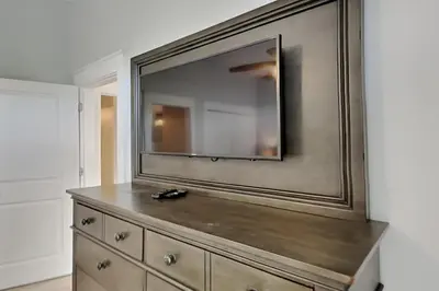 a dresser with a large mirror on a wall at Magnolia House in Seagrove Beach