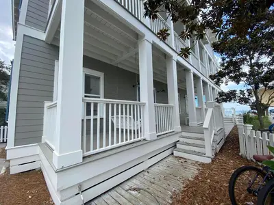 a porch with white railings on a house at Magnolia House in Seagrove Beach