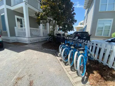 a row of blue bikes parked in front of a house at Magnolia House in Seagrove Beach
