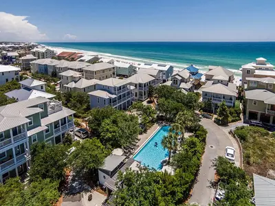 an aerial view of a resort with a pool and the beach at Magnolia House in Seagrove Beach
