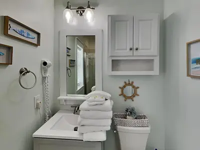a bathroom with a sink and a toilet and a mirror at Bungalows at Seagrove #138 in Seagrove Beach