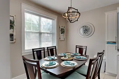 a dining room with a table with chairs and a chandelier at Bungalows at Seagrove #138 in Seagrove Beach