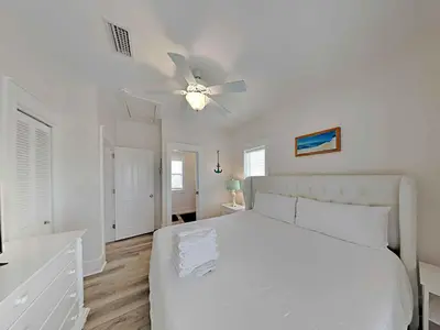 a white bedroom with a white bed and a ceiling fan at Bungalows at Seagrove #132 - Kruks Fanta Sea in Seagrove Beach
