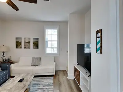 a living room with a white couch and a tv at Bungalows at Seagrove #132 - Kruks Fanta Sea in Seagrove Beach