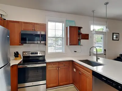 a kitchen with wooden cabinets and a stove top oven at Bungalows at Seagrove #132 - Kruks Fanta Sea in Seagrove Beach