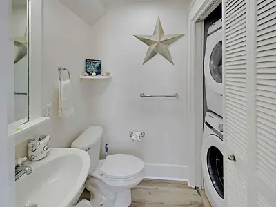 a white bathroom with a toilet and a sink at Bungalows at Seagrove #132 - Kruks Fanta Sea in Seagrove Beach