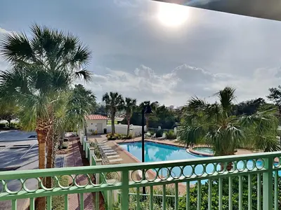 a balcony with a pool and palm trees at Inn at Seacrest #206 in Rosemary Beach