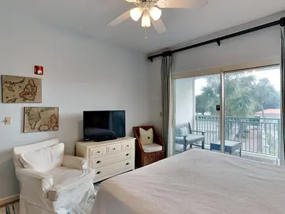 a bedroom with a bed and a tv and a balcony at Inn at Seacrest #206 in Rosemary Beach