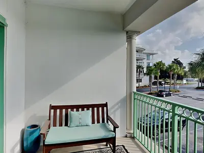 a chair on a balcony with a view of a street at Inn at Seacrest #206 in Rosemary Beach