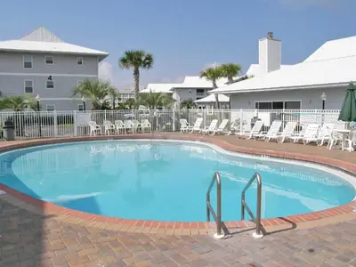 a large swimming pool with chairs and a building at Beachside Villas #413 in Seagrove Beach