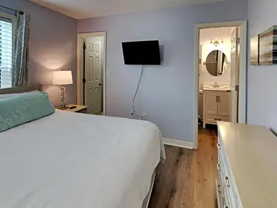 a bedroom with a white bed and a television at Beachside Villas #413 in Seagrove Beach