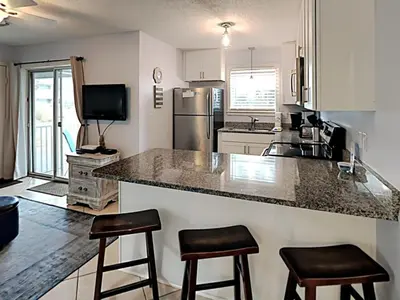a kitchen with a counter and two bar stools at Beachside Villas #413 in Seagrove Beach