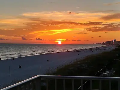 a sunset at the beach with a crowd of people at Nautical Watch A-11 in Panama City Beach