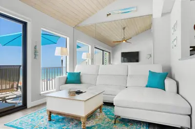 a living room with a white couch and a table at Nautical Watch A-11 in Panama City Beach