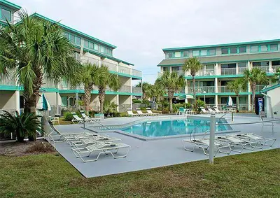a swimming pool with lounge chairs and a building at Nautical Watch A-11 in Panama City Beach