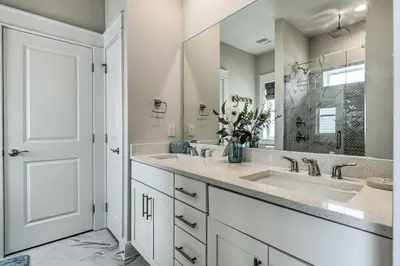 a bathroom with two sinks and a large mirror at Inlet Beach Cottage Close to Beach Access! in Inlet Beach