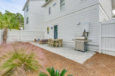 a patio with a table and a grill next to a house at Inlet Beach Cottage Close to Beach Access! in Inlet Beach
