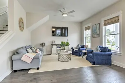 a living room with blue chairs and a ceiling fan at Inlet Beach Cottage Close to Beach Access! in Inlet Beach