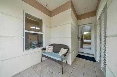 a porch with a chair and a window at Legacy 506- The Coastal Gem in Santa Rosa Beach