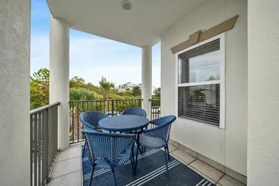 a patio with a table and chairs on a balcony at Legacy 506- The Coastal Gem in Santa Rosa Beach