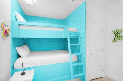 a bunk bed in a room with blue walls at Legacy 506- The Coastal Gem in Santa Rosa Beach