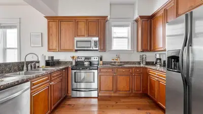 a kitchen with wooden cabinets and stainless steel appliances at Chic 30A Beach Home Views Ping Pong 5-Min Walk to Carillon Beach Bellview in Sunnyside