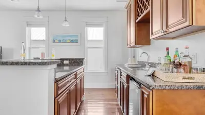 a kitchen with white walls and wooden cabinets at Chic 30A Beach Home Views Ping Pong 5-Min Walk to Carillon Beach Bellview in Sunnyside