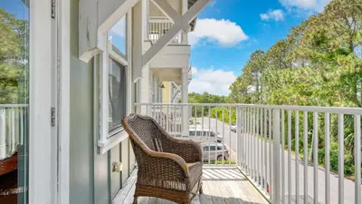 a wicker chair sitting on the porch of a house at Chic 30A Beach Home Views Ping Pong 5-Min Walk to Carillon Beach Bellview in Sunnyside