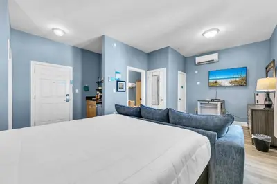 a bedroom with a large bed and a couch at Village of South Walton B377-G in Rosemary Beach