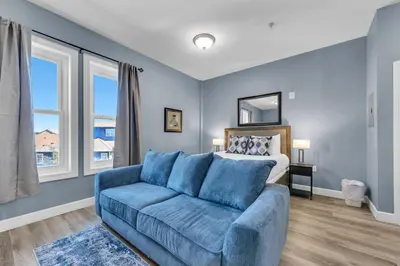 a living room with a blue couch and a bed at Village of South Walton B377-G in Rosemary Beach