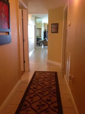 a hallway with a rug on a tile floor at Celadon Beach Resort in Panama City Beach