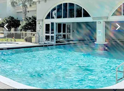 a large swimming pool in front of a building at Celadon Beach Resort in Panama City Beach
