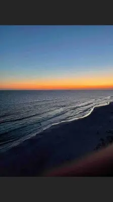 a view of the ocean from a beach at sunset at Celadon Beach Resort in Panama City Beach