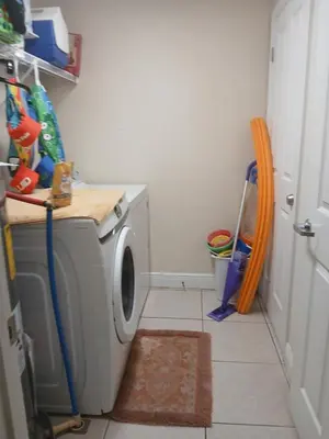 a small laundry room with a washing machine in it at Celadon Beach Resort in Panama City Beach
