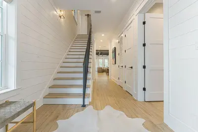 a staircase in a house with white walls and wooden floors at The Crown Jewel of Seacrest Beach in Inlet Beach
