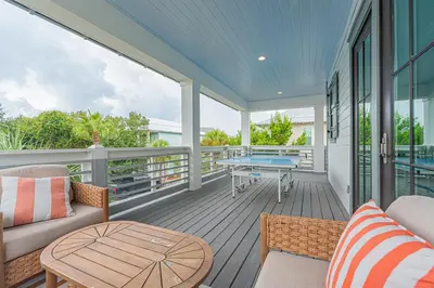 a screened porch with a couch and a table at The Crown Jewel of Seacrest Beach in Inlet Beach