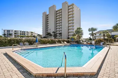 a swimming pool with a large building in the background at 30A Emerald Hill Beach Resort by Panhandle Getaways in Santa Rosa Beach